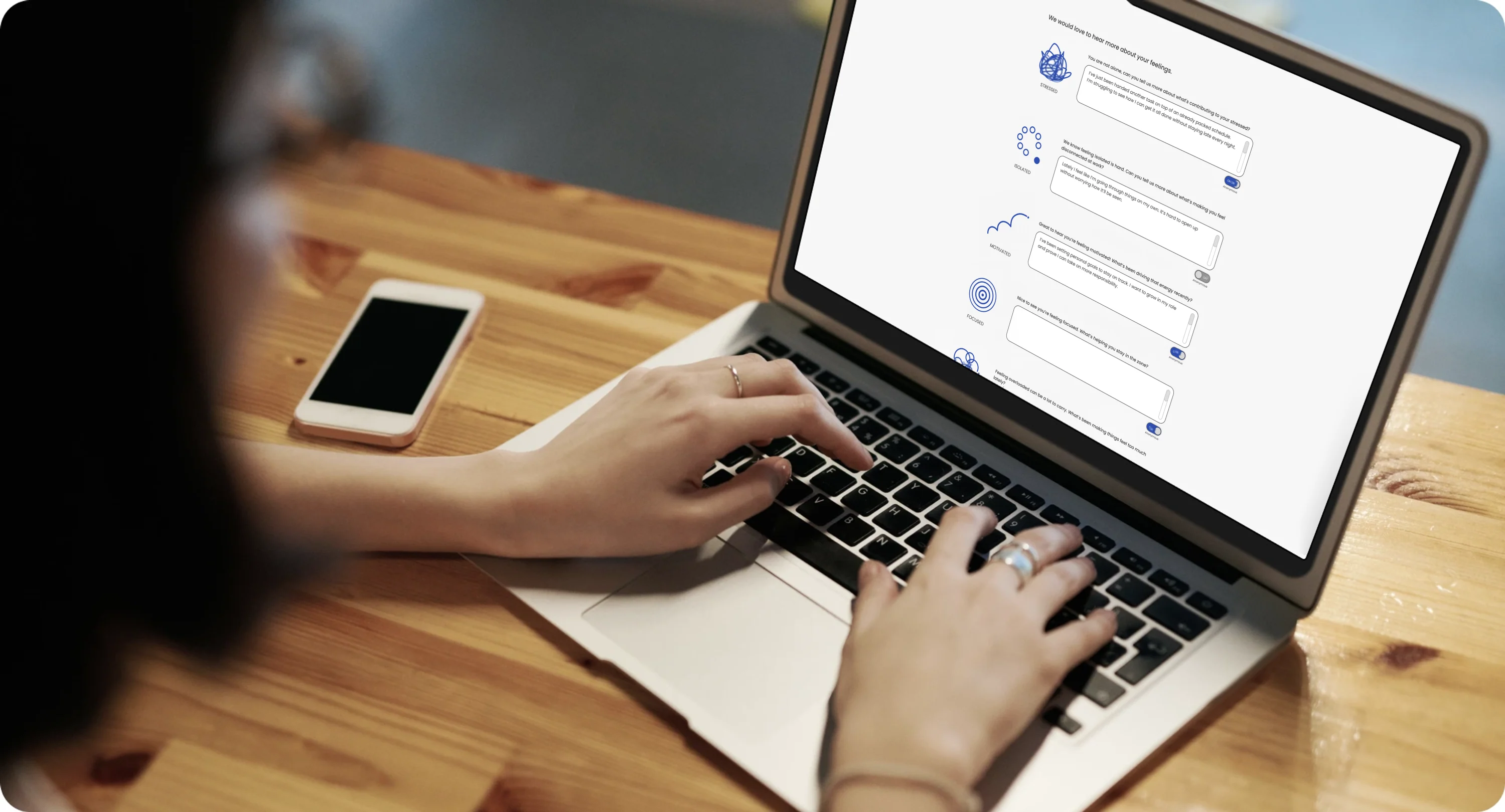 A person typing on a laptop that shows the Reflect emotional check-in screen